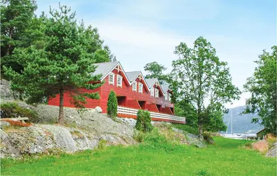 a red house sitting on top of a hill at Nice Home In Hatlestrand in Hatlestrand