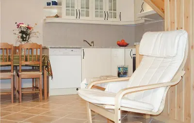 a room with a white chair in a kitchen at Lovely Home In Hatlestrand With Kitchen in Hatlestrand