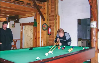 a man playing a game of pool in a room at Lovely Home In Hatlestrand With Kitchen in Hatlestrand