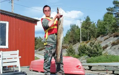 a statue of a man holding a fish on a pole at Lovely Home In Hatlestrand With Kitchen in Hatlestrand