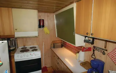 a small kitchen with a stove and a sink at Petterbua in Norheimsund