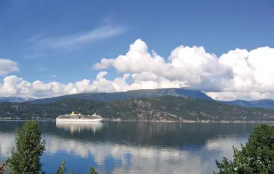 a cruise ship on a large lake with mountains at Holiday Home Jondal Torsnes in Jondal