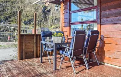 a patio with chairs and a table on a deck at Stunning Home In Os With Kitchen in Oma