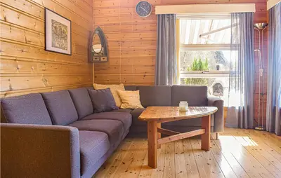 a living room with a couch and a table at Stunning Home In Os With Kitchen in Oma