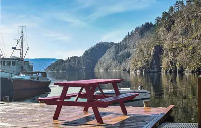 a picnic table sitting on a dock next to a boat at Stunning Home In Os With Kitchen in Oma
