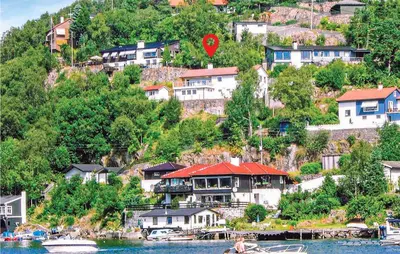 a group of houses on a hill next to the water at Cozy Apartment In Straumsgrend in Bergen