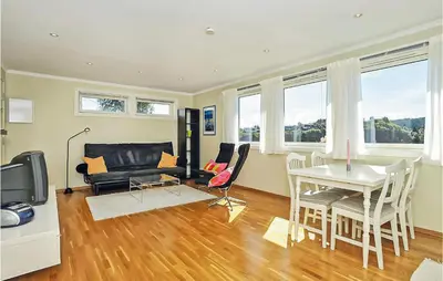a living room with a table and a couch at Cozy Apartment In Straumsgrend in Bergen