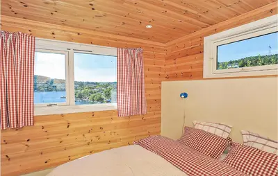 a bedroom with a bed and two windows at Cozy Apartment In Straumsgrend in Bergen