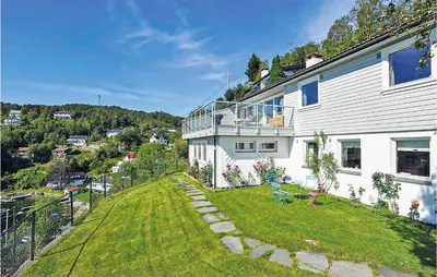 a large white house with a large yard with chairs at Cozy Apartment In Straumsgrend in Bergen