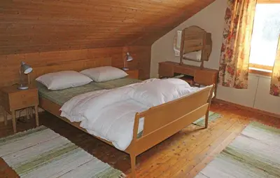 a bedroom with a large bed and a wooden ceiling at Holiday Home Evanger Brekkhuslii in Evanger
