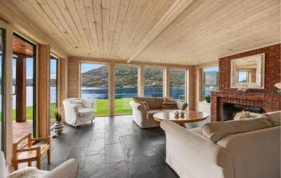 a living room filled with furniture and a fireplace at Sørkvingo in Masfjorden