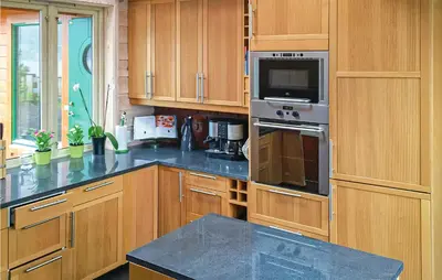 a kitchen with wooden cabinets and a stove top oven at Sørkvingo in Masfjorden