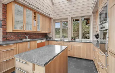 a kitchen with wooden cabinets and a counter top at Sørkvingo in Masfjorden