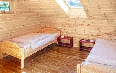 a bedroom with two beds in a log cabin at Gorgeous Home In Hagavik in Hagavik
