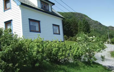 a white house with a hill in the background at Holiday Home Sørbøvåg Sandnes in Sandnes