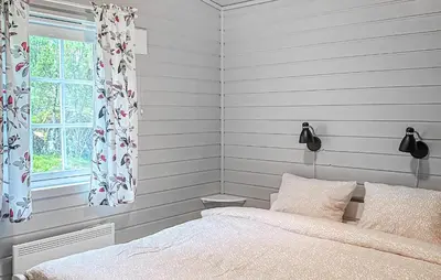 a white bedroom with a bed and a window at Cozy Home In Lavik With House Sea View in Lavik
