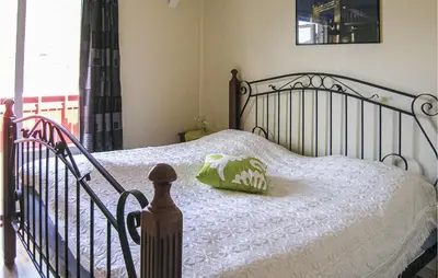 a bedroom with a bed with a green pillow on it at Gorgeous Home In Dalsøyra With Kitchen in Dalsøyra