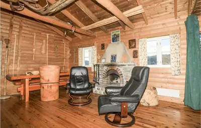a room with two chairs and a fireplace in a log cabin at 2 Bedroom Beautiful Home In Balestrand in Balestrand