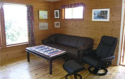 a living room with a couch and a table and a chair at Holiday Home Balestrand Stokkabø in Balestrand