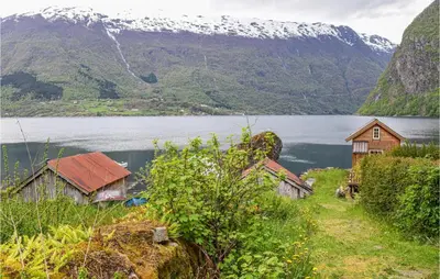 a group of houses on a hill next to a body of water at Nice Home In Vik I Sogn With Jacuzzi in Åse
