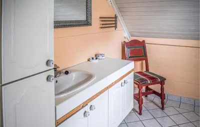 a bathroom with a sink and a chair at Nice Home In Vik I Sogn With Jacuzzi in Åse