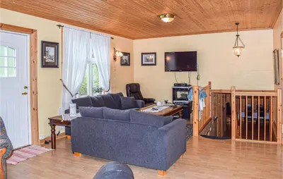 a living room with a couch and a tv at Nice Home In Vik I Sogn With Jacuzzi in Åse