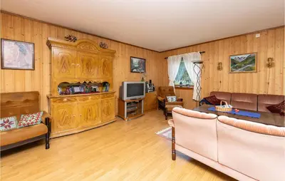 a living room with wooden paneling and a television at Beautiful Home In Jostedal With Kitchen in Jostedal