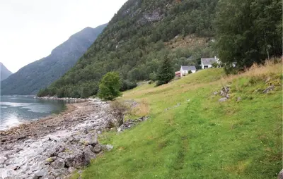 a house on a hill next to a body of water at Naddvik in Årdalstangen