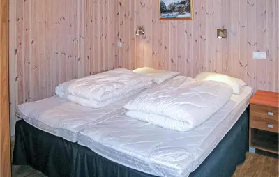 a bed with white sheets on it in a room at Stunning Home In Sogndal With Sauna in Sogndal