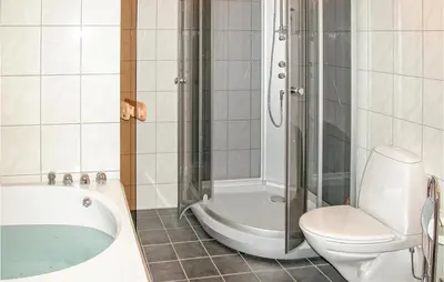 a bathroom with a tub and a toilet and a shower at Stunning Home In Sogndal With Sauna in Sogndal