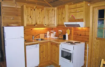 a kitchen with white appliances and wooden cabinets at Beautiful Home In Skei I Jølster in Årdal