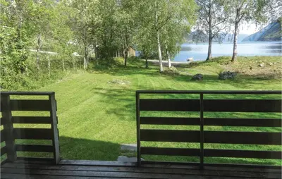 a view of a field of grass and a body of water at Gorgeous Home In Ålfoten With Sauna in Ålfoten