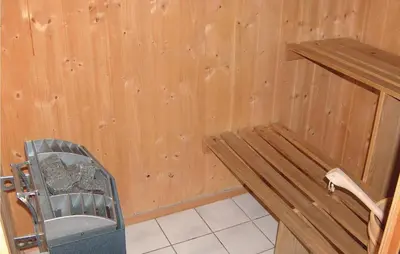 a wooden room with a bench and a chair at Gorgeous Home In Ålfoten With Sauna in Ålfoten