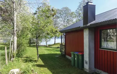 a red house with a window and a yard at Gorgeous Home In Ålfoten With Sauna in Ålfoten
