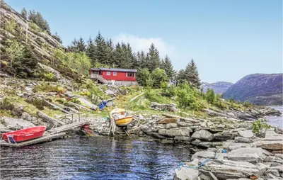 a couple of boats sitting on the side of a river at Holiday Home Måløy Husevåg in Måløy