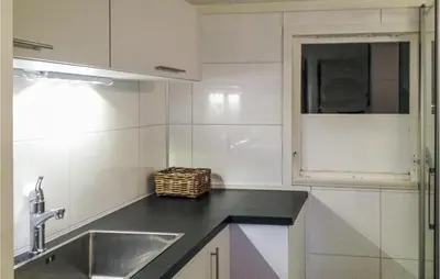 a white kitchen with a sink and a window at Holiday Home Måløy Husevåg in Måløy