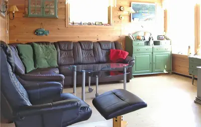 a living room with a couch and a table at 3 Bedroom Awesome Home In Måløy in Måløy