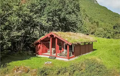 a small red house with a grass roof on a hill at Flåten Hyttegrend in Olden
