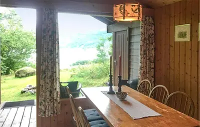 a dining room with a table and a large window at Flåten Hyttegrend in Olden