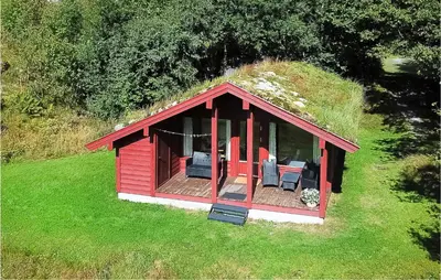a small red cabin with a grassy roof at Flåten Hyttegrend in Olden
