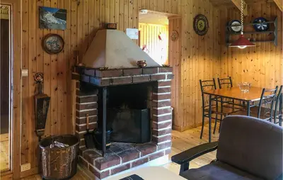 a living room with a brick fireplace and a table at Holiday Home Olden Gjerde in Olden