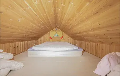a bedroom with a bed in a wooden room at 3 Bedroom Amazing Home In Sandane in Sandane