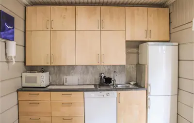 a kitchen with wooden cabinets and a white refrigerator at Amazing Home In Olden With Wifi in Olden