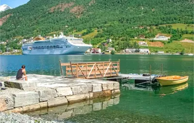 a cruise ship is docked at a dock with a boat at Amazing Home In Olden With Wifi in Olden
