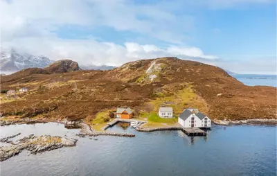 an island in the water with houses and a mountain at Holiday Home Kvamsøy Storholmen in Sandvik