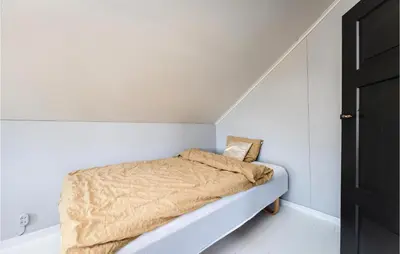 a small bedroom with a bed in a white room at Holiday Home Kvamsøy Storholmen in Sandvik