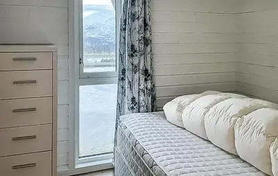 a bedroom with a bed with a window and a bedskirts at Stunning Home In Stranda With Sauna in Stranda