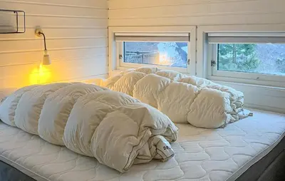a large white bed in a room with two windows at Stunning Home In Stranda With Sauna in Stranda