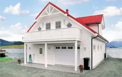 a white house with a red roof and a garage at Sandshamn in Sandshamn