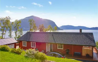 a red house with a mountain in the background at 4 Bedroom Beautiful Home In Hundeidvik in Hundeidvik